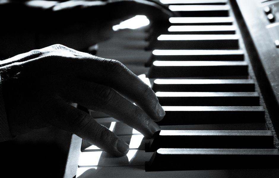 Close-up of hands playing piano keys.