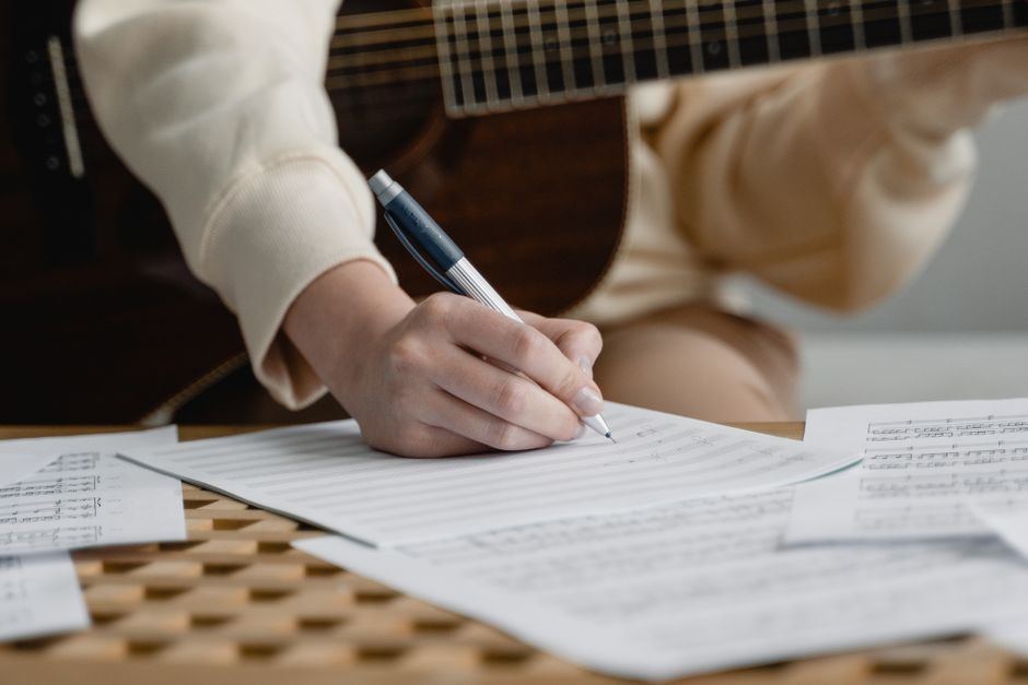 Two musicians sitting together, working on a song.
