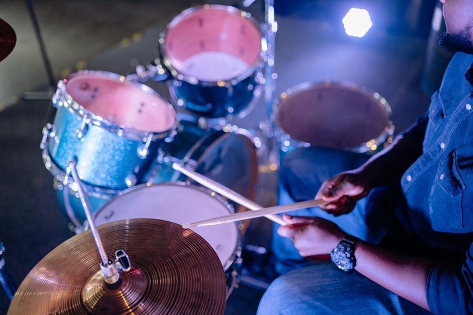 A drummer playing a drum kit mid-performance.