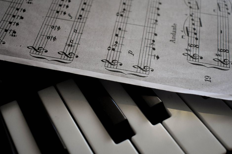 Sheet music resting on a piano, open to a page of notation.